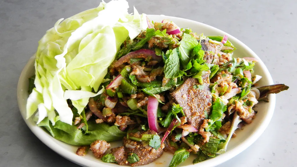 A bowl of Larb, with beef, mint, onions, greens and other aromatics.