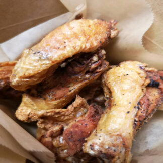Crispy fried chicken wings with golden breading in a bowl.